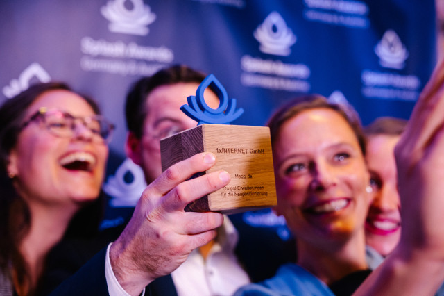 Jubelnde Personen mit einem der Splash Awards in der Hand in Richtung der Kamera
